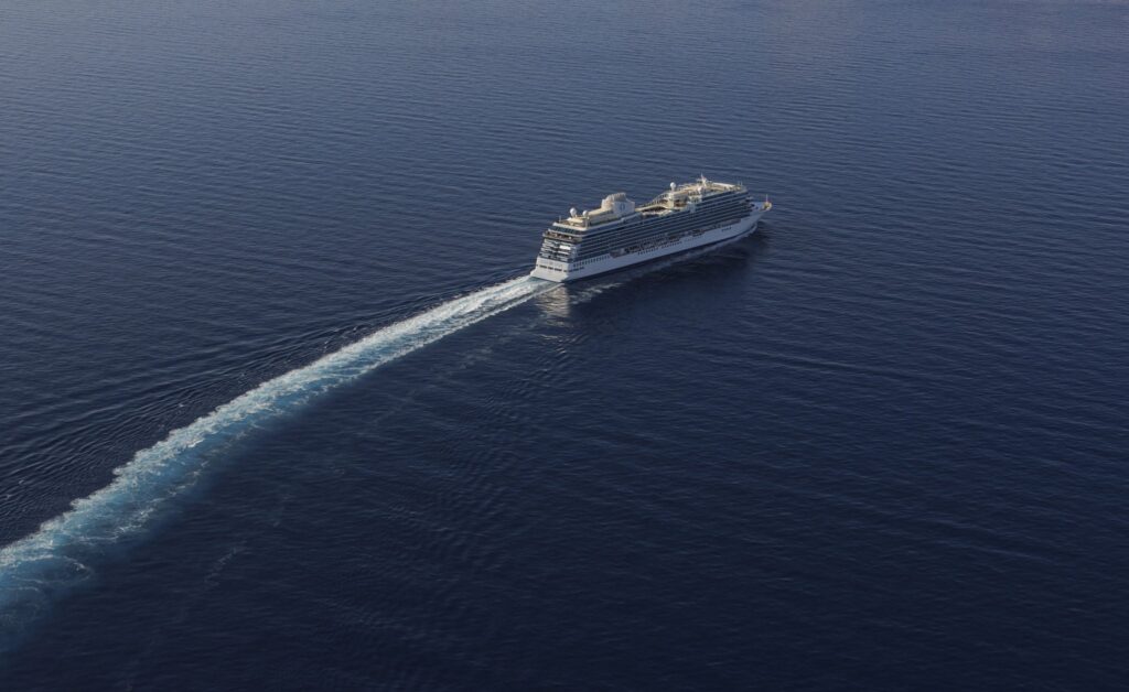 Oceania Allura cruise ship sailing on blue ocean, modern luxury vessel with elegant design