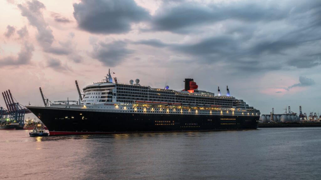Queen Mary 2 Cunard ocean liner sailing at sunset
